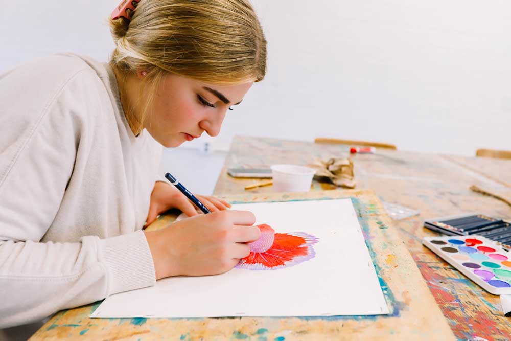 student coloring with colored pencil