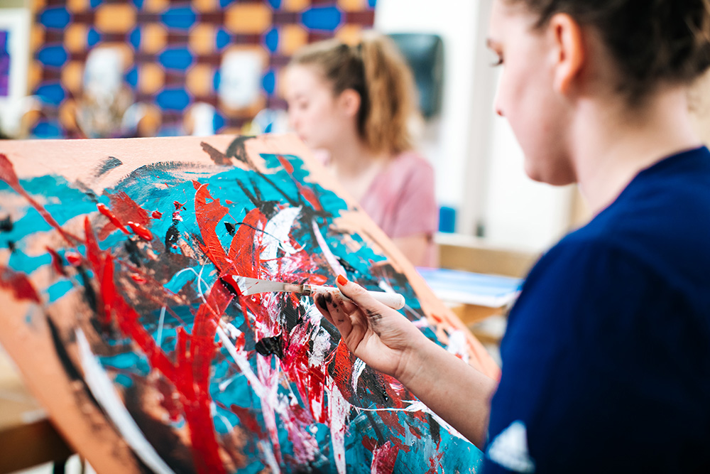 student painting on canvas