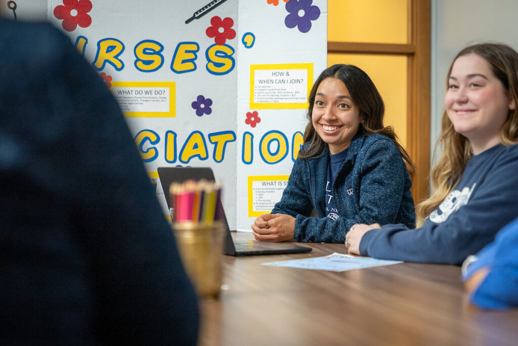 Students gather at a table for a campus information session about student nursing association organization at College of Saint Mary.