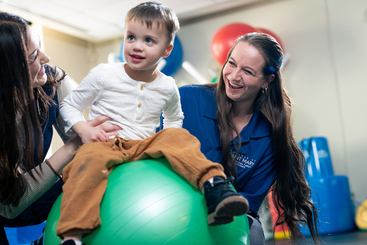 boy balancing on ball during therapy session