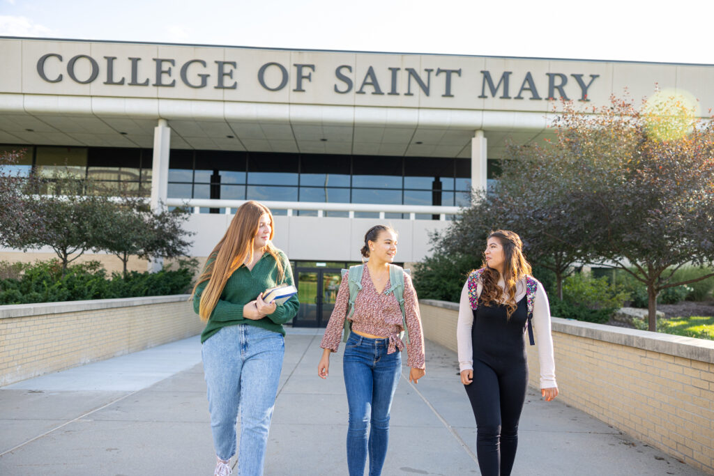 The students walking outside Mercy Hall talking to each other