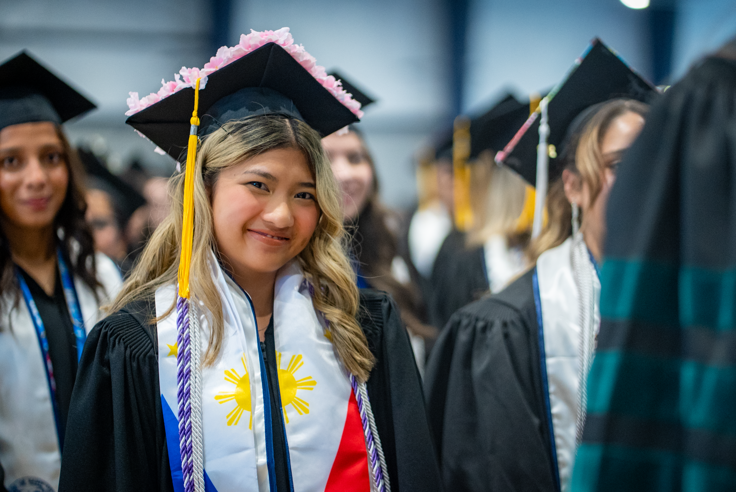 A student poses at graduation in 2026.